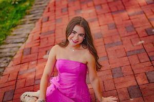 Young woman sits on a brick path