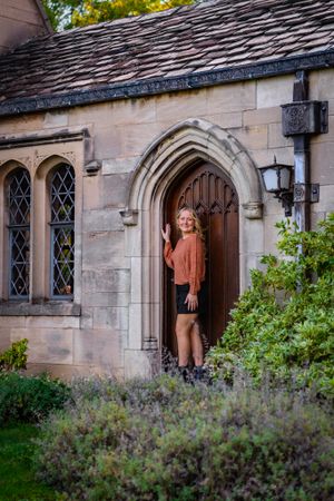 senior girl poses in a doorway