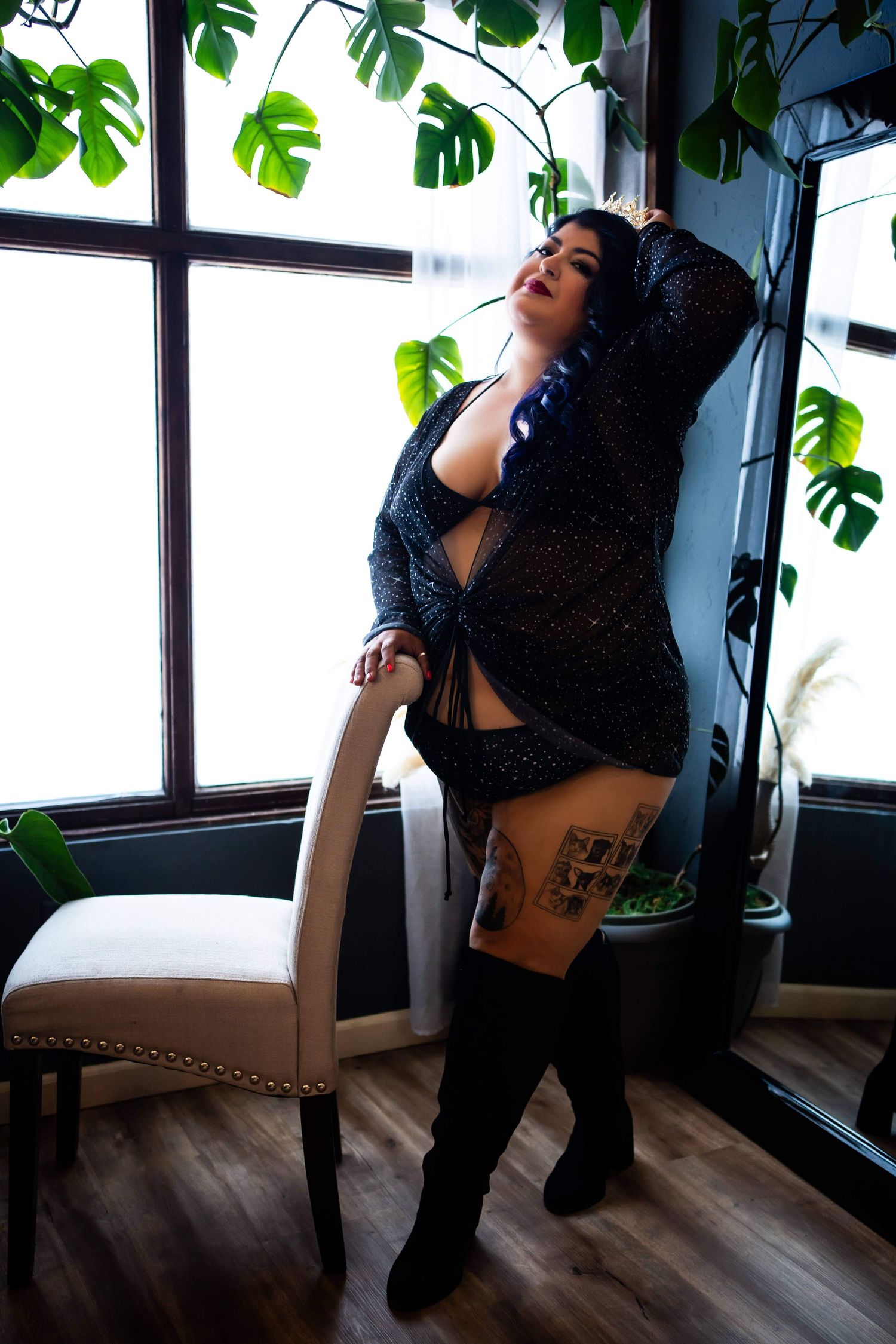 Indoor boudoir session with houseplants and ambient lighting creating intimate atmosphere.