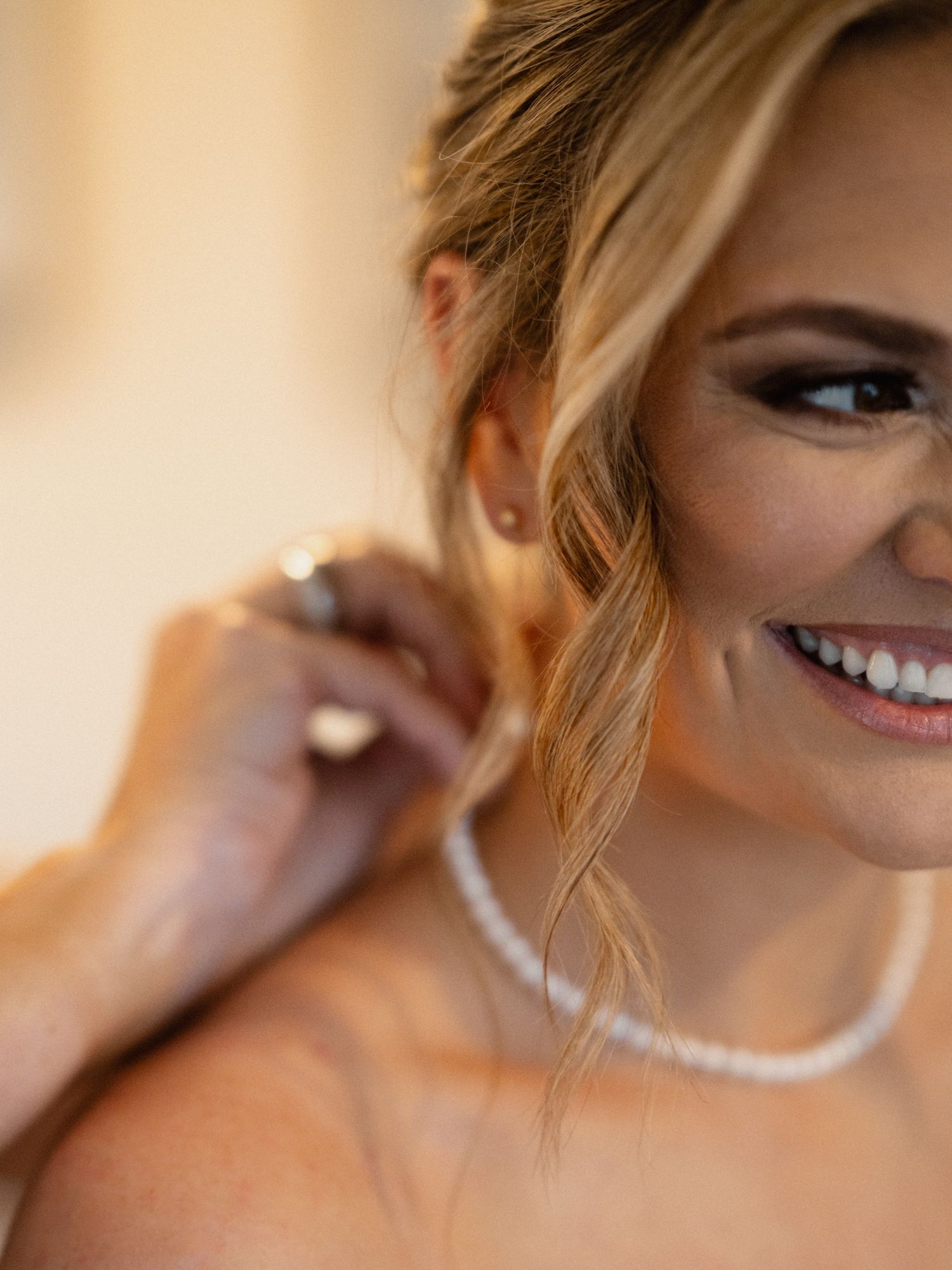 Close-up shot of elegant bridal makeup and pearl necklace.