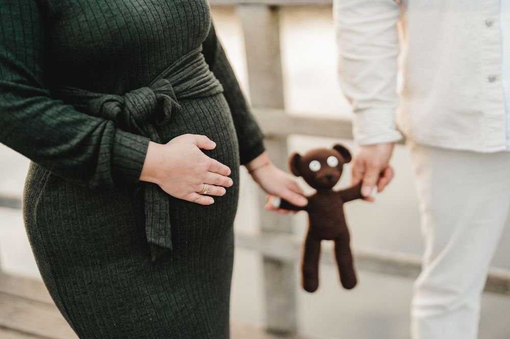 Babybauch-Paarbilder bei Sonneuntergang auf dem Federseesteg in Bad Buchau im Frühjahr