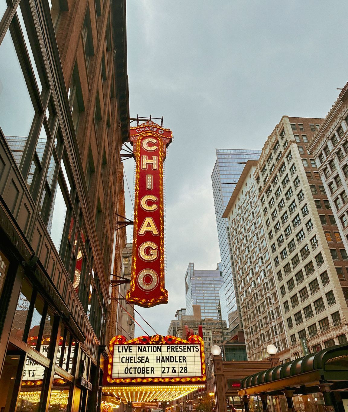 Historic Chicago Theatre marquee and signs along city street at dusk photographed by Gia Quilap.