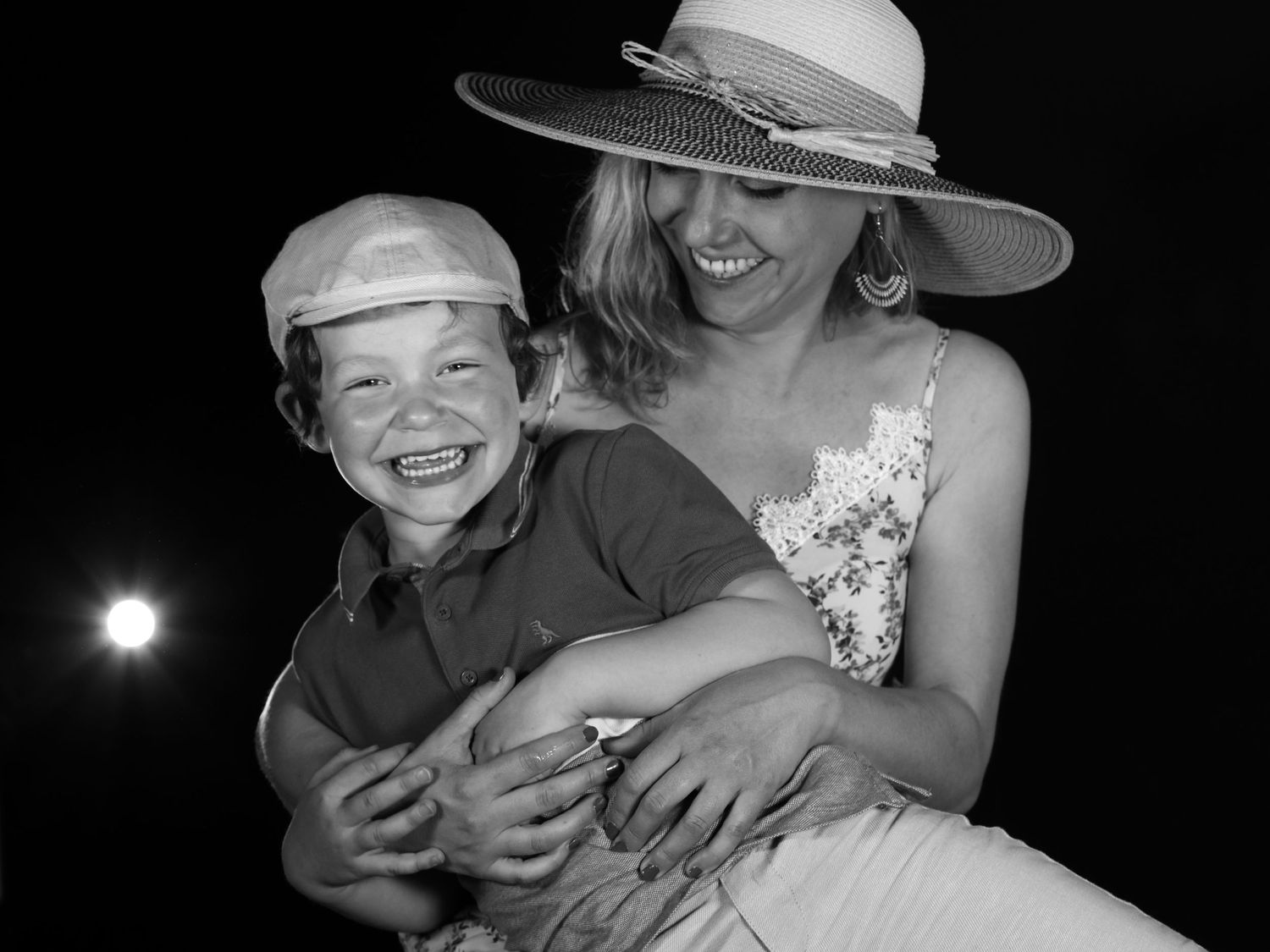 A heartwarming black and white candid photo shows joyful laughter shared between two people on a summer evening.
