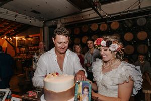 A rustic wine barrel room decorated for a wedding celebration with warm lighting and romantic ambiance.