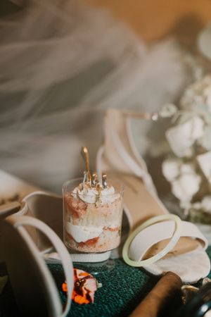 Close-up view of a delicate dessert parfait with whipped cream and garnish served in a small glass container.