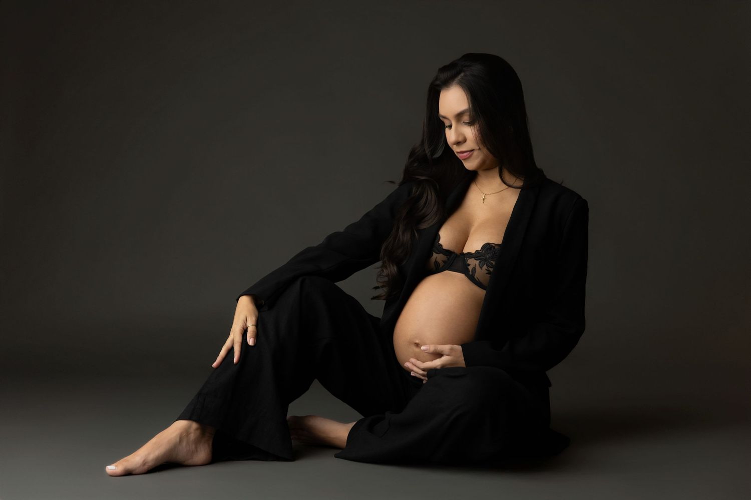 A series of artistic boudoir photos featuring a woman in black lingerie posing against a dark background.