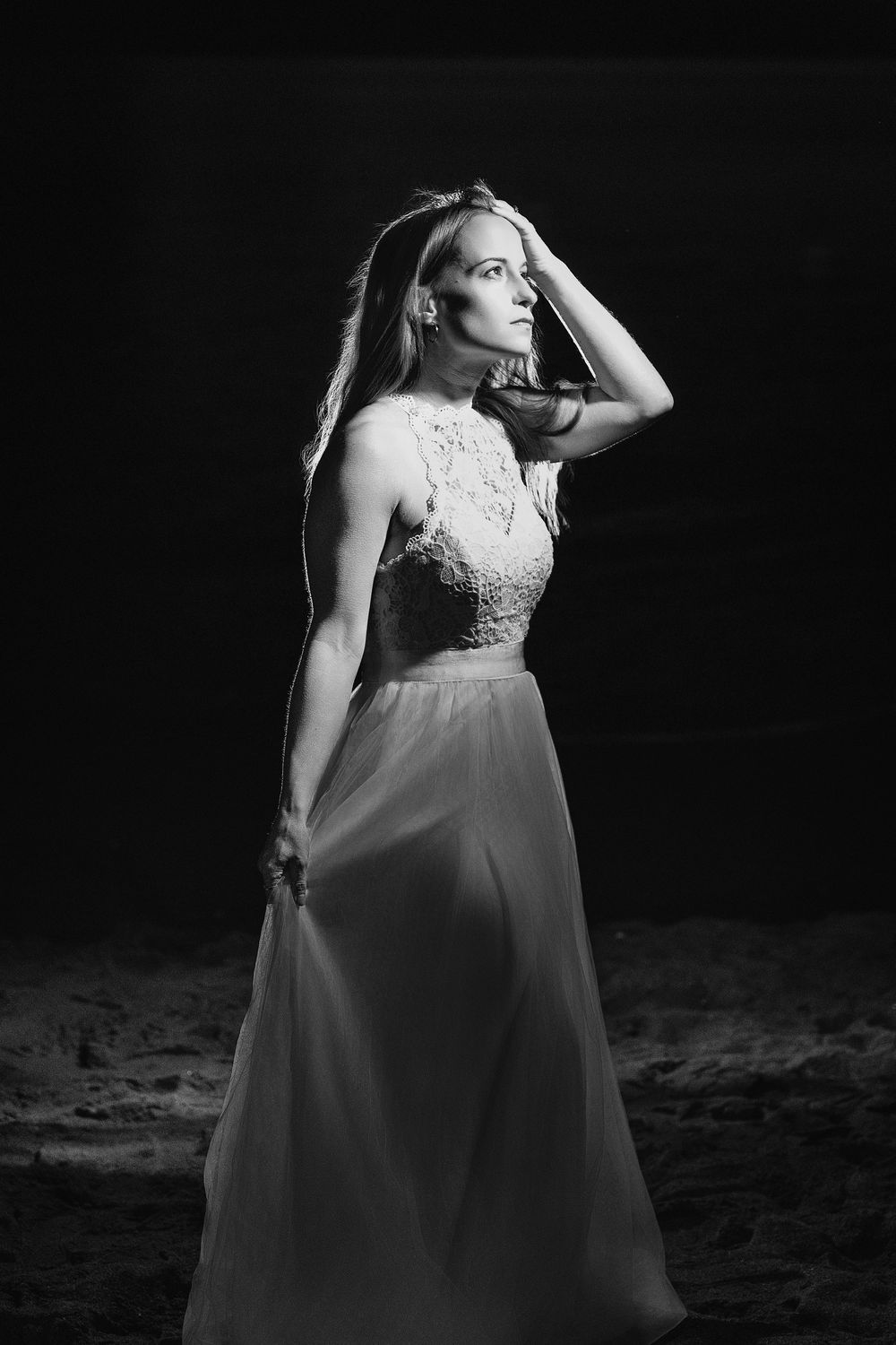 Dramatic black and white portrait series showing a woman in a flowing white dress against a dark background.