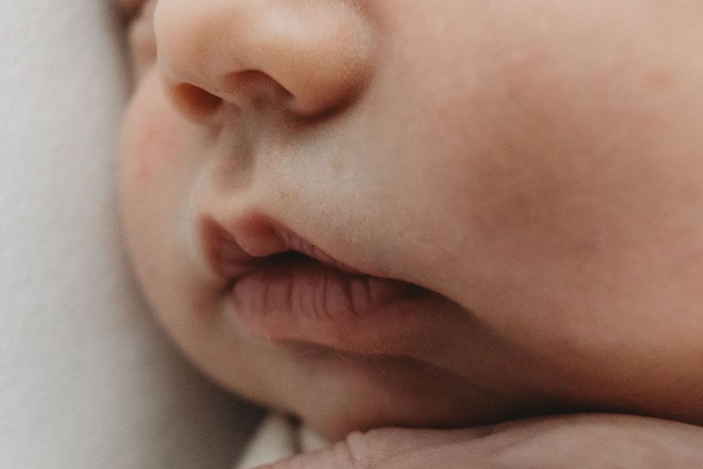 Close-up of a sleeping newborn baby's nose and lips, showcasing delicate infant features.