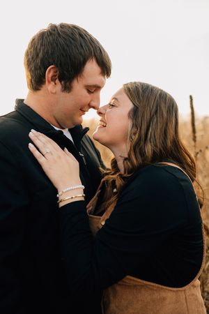 An engaged couple shares an intimate moment in casual winter wear.