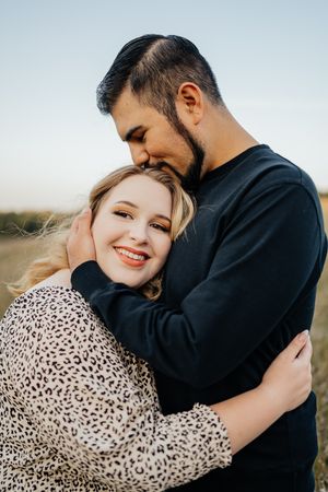 Couple sharing intimate moment during outdoor engagement photo session.