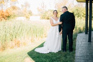 A romantic outdoor wedding portrait with a couple posing against a golden sunset backdrop.