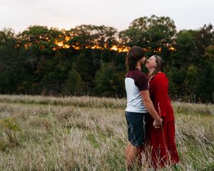 Sunset wedding photos in a rustic field with warm golden light.