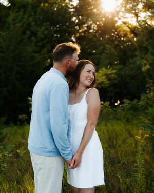Couple sharing an intimate moment in a sunlit garden setting.