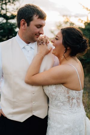 Romantic wedding couple shares intimate dance poses at sunset in elegant attire.