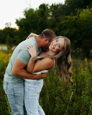 A romantic couple in matching mint green outfits embraces while sharing intimate moments in a wildflower field.