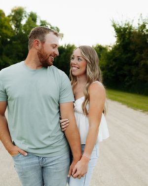 Casual couple walking together on a country road during golden hour.