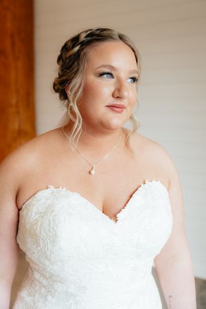 A close-up portrait in a white strapless lace wedding dress with an elegant updo hairstyle.