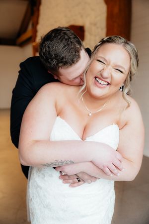 Candid moment of joyful laughter between couple during wedding portraits.