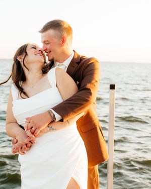 Romantic seaside wedding photos with couple embracing against ocean backdrop at sunset.