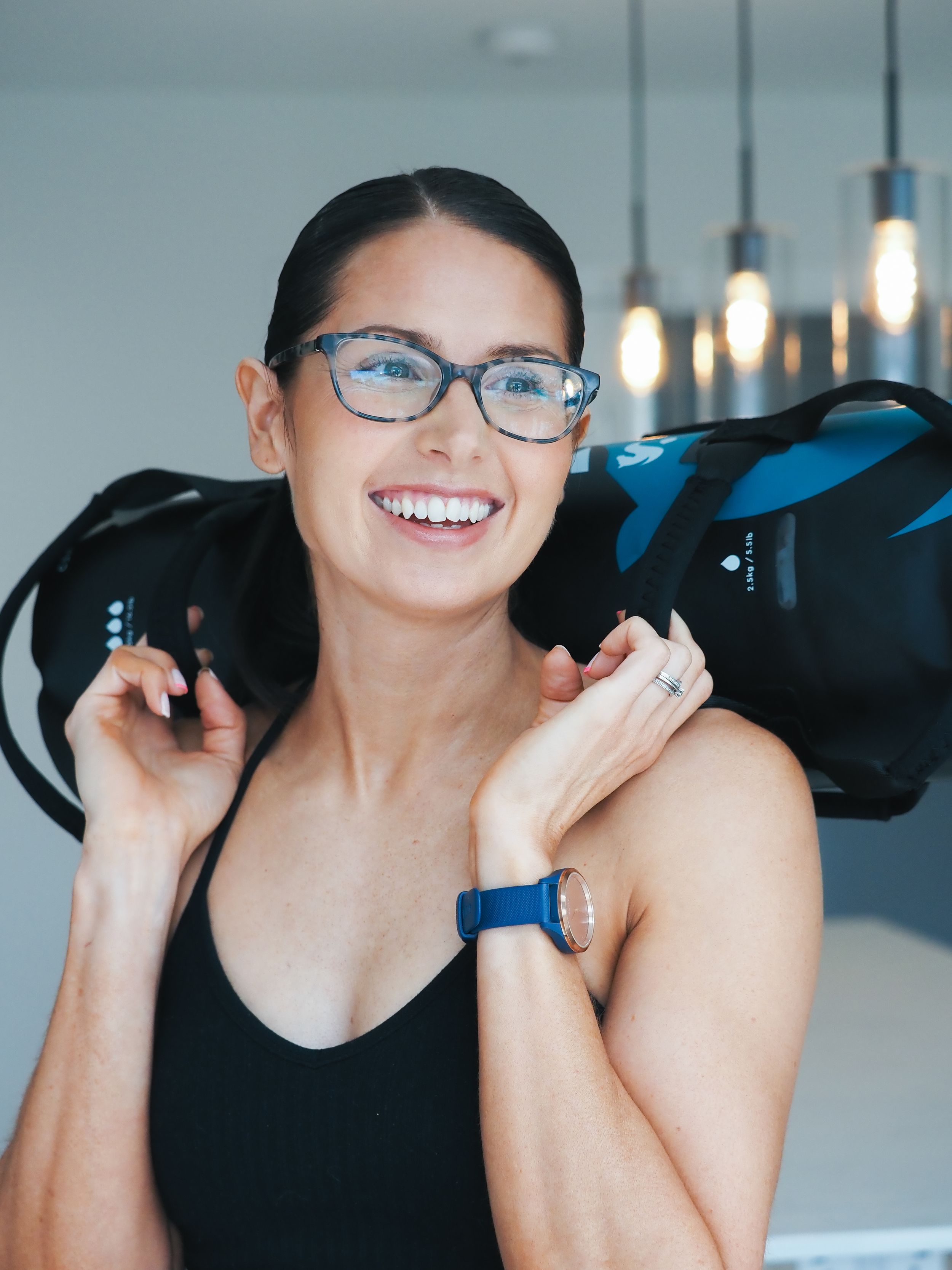 A person wearing glasses and a sleeveless top smiles brightly in a series of candid portrait shots.