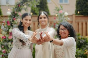 A celebratory moment in front of a floral arch during a wedding ceremony.