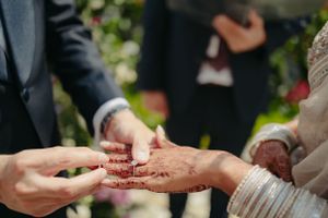 A close-up shot of hands exchanging rings during a wedding ceremony.