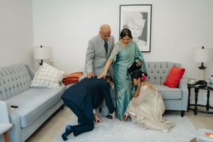 A tender moment shared in a living room with light gray couches and decorative pillows.