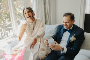 A joyful moment shared between newlyweds looking at something on a phone.