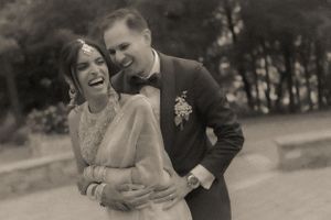 A joyful black and white wedding photo showing the couple laughing together.