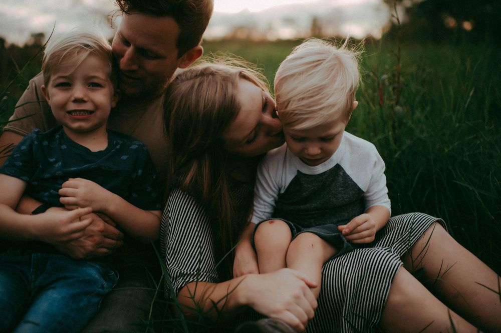 A series of intimate family moments captured in black and white showing tender embraces outdoors.