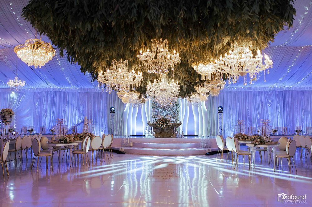 Luxurious ballroom with crystal chandeliers and dramatic white drapery creating an ethereal atmosphere.