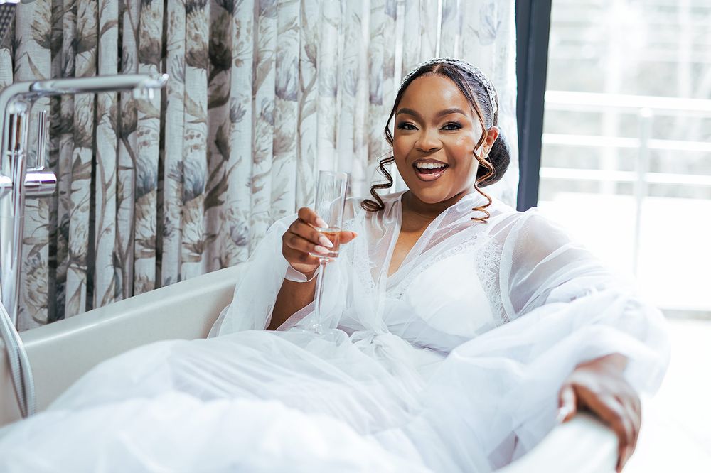 A joyful moment captured of someone in white loungewear relaxing in bed.