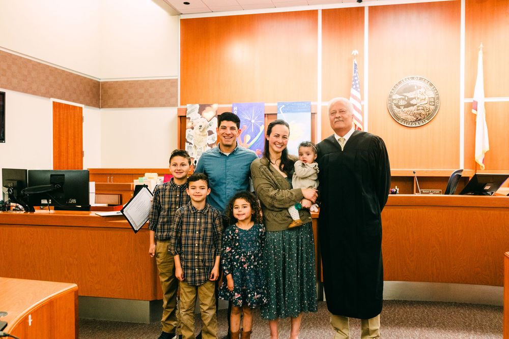 Family of 6 standing with the judge at court for their adoption hearing, Santa Maria, CA