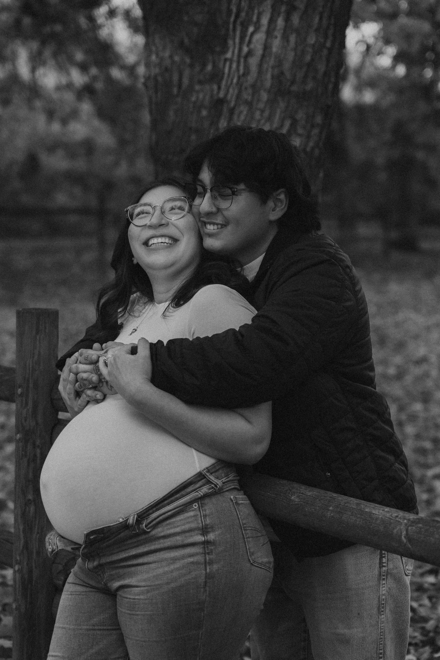 Candid black and white photo sequence of couple embracing by tree.