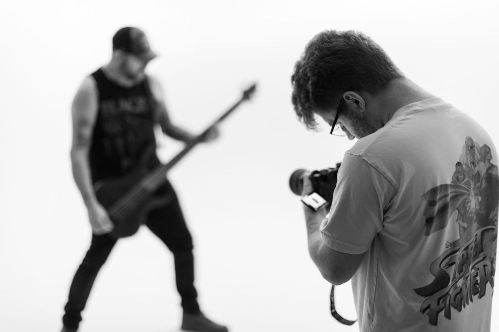 Black and white photo of band members performing with guitars and microphones.