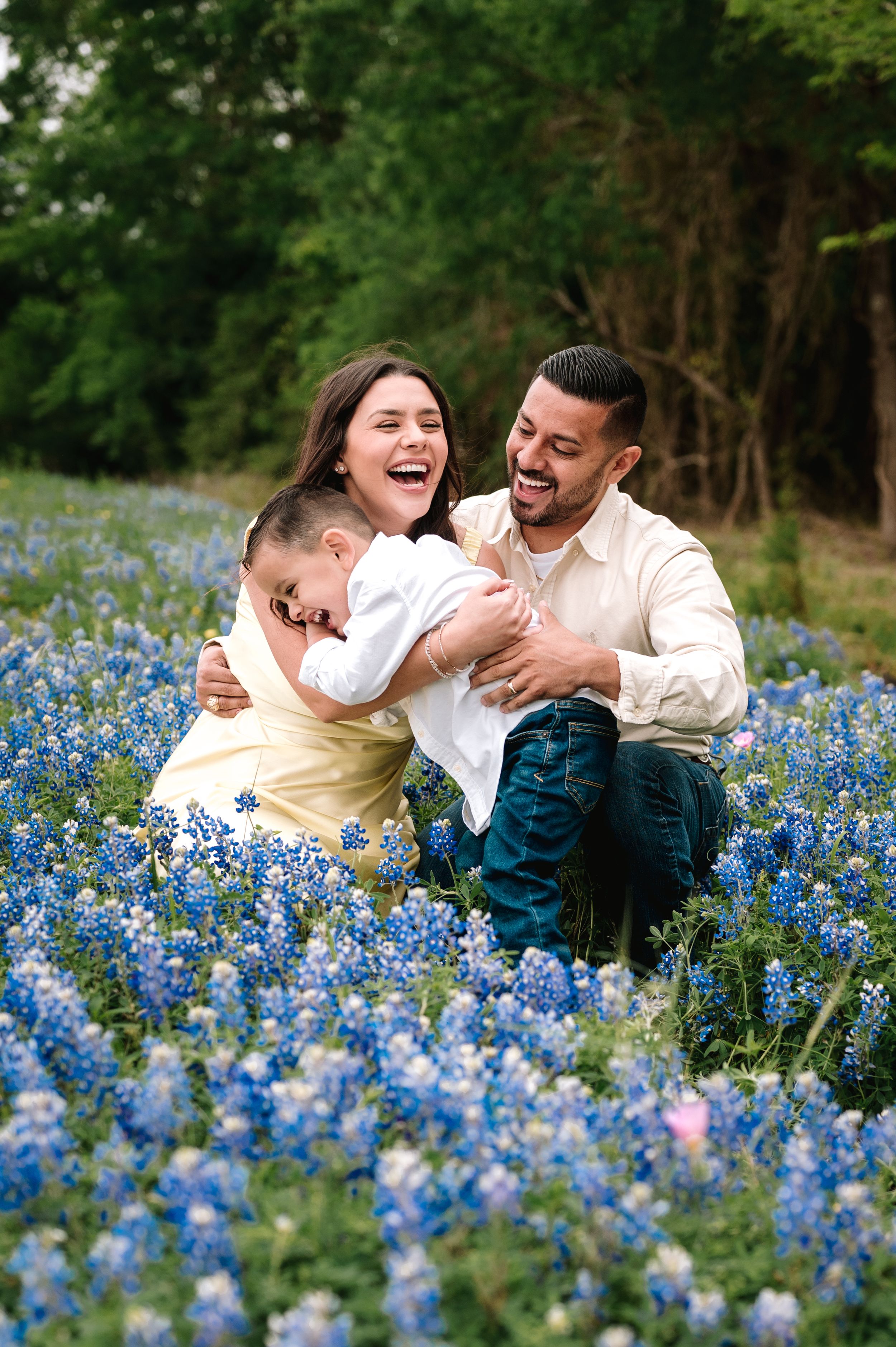 A joyful candid moment captured in a field of blooming Texas bluebonnets during springtime.