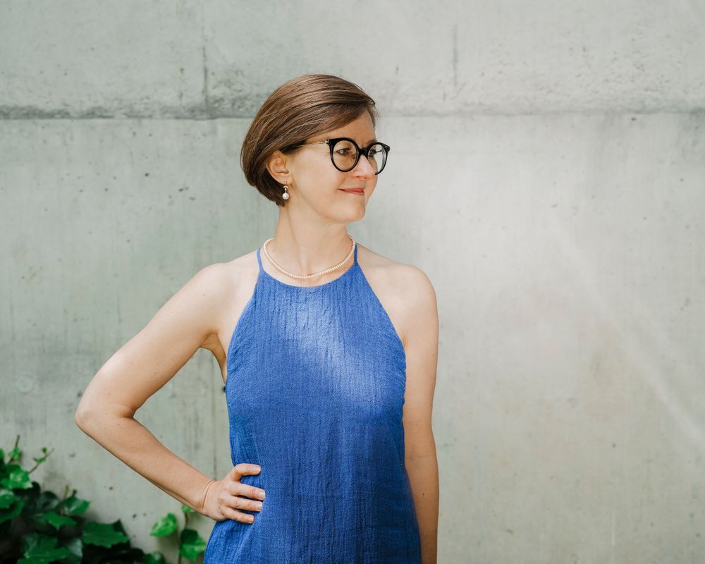 An elegant woman standing against the wall.