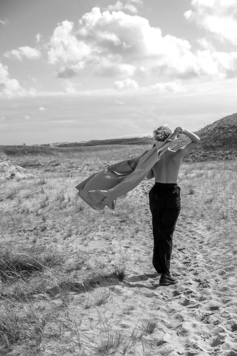 A woman's portrait with a coat at the seaside.