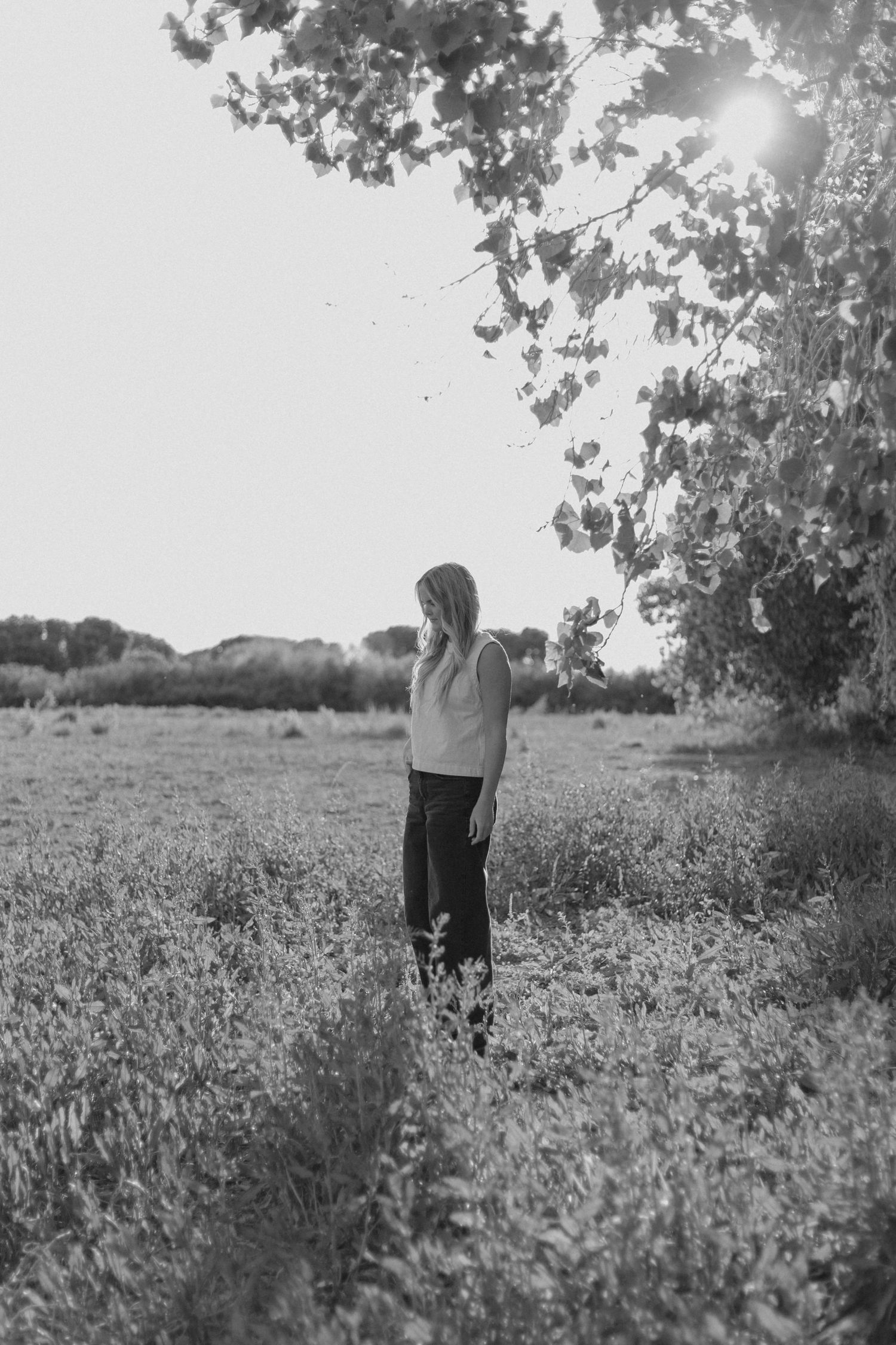Black and white portrait session in scenic meadow landscape.