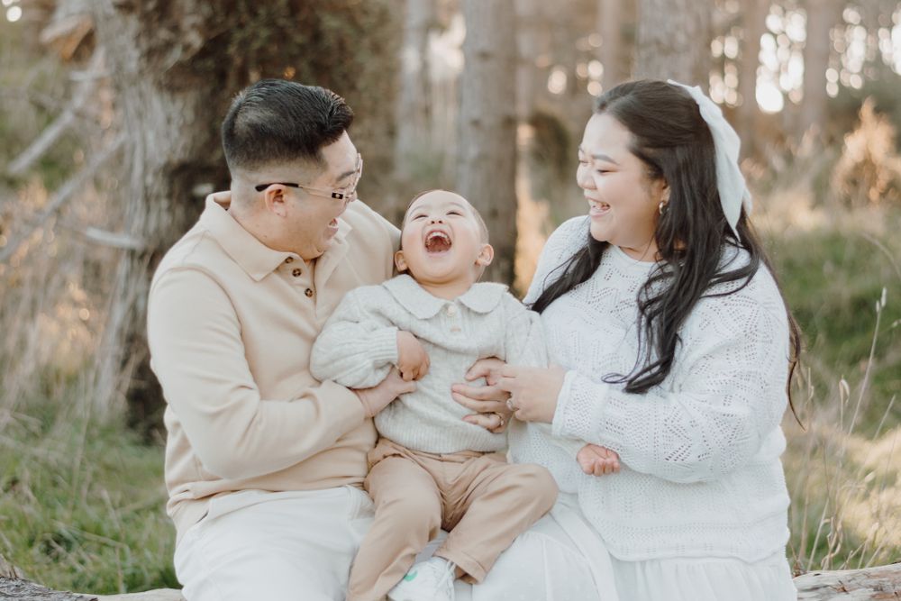 A joyful family moment captured outdoors wearing coordinated white outfits.