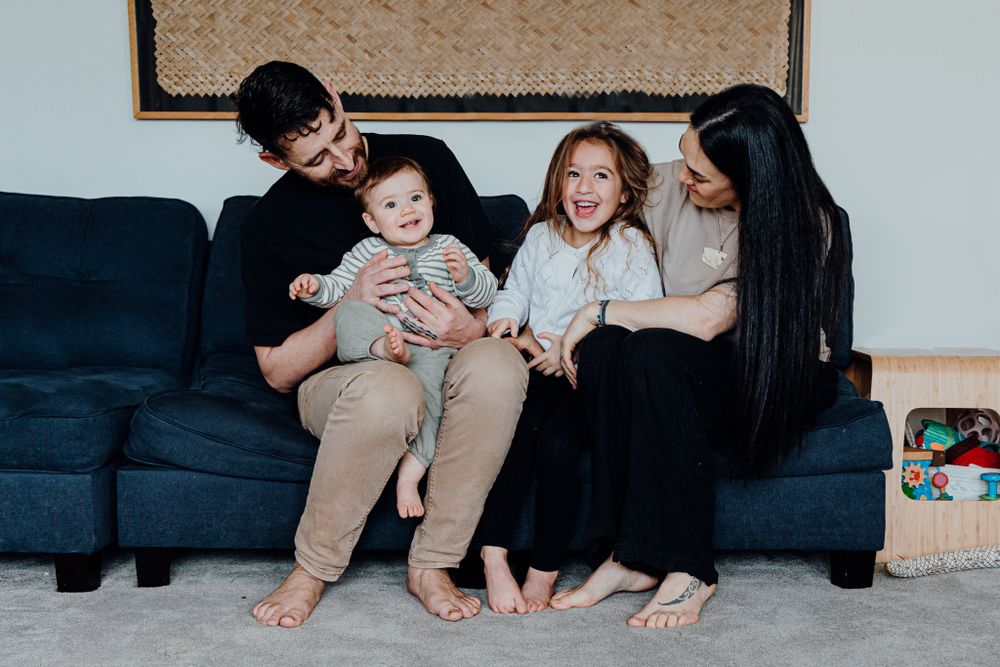 Casual family moment captured on a blue couch in a home setting.