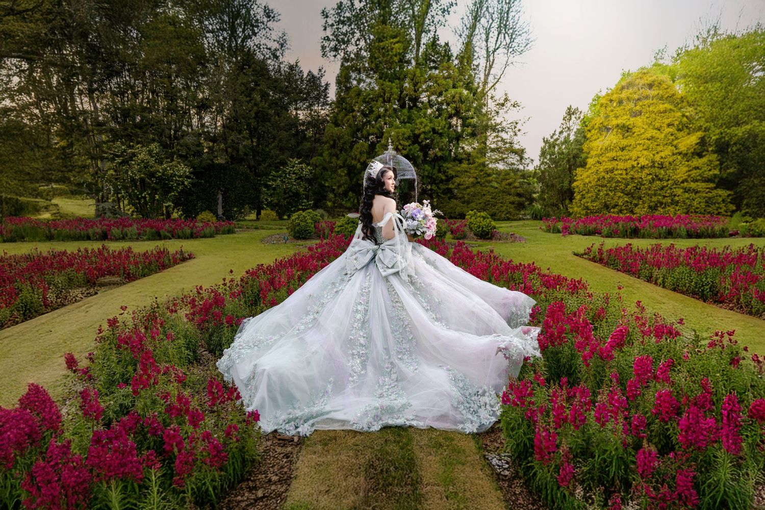 Ethereal bridal portrait amidst vibrant purple snapdragon flowers in a manicured garden.