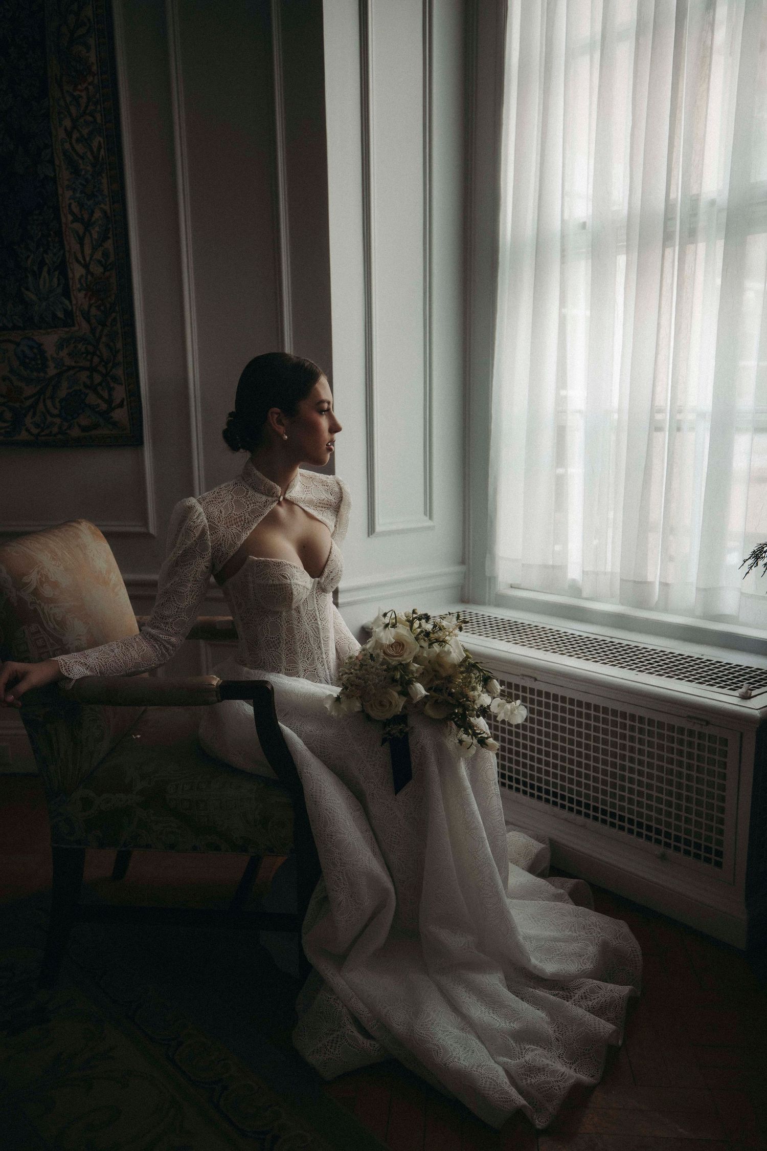 Close-up portrait of a bride wearing a delicate lace veil and crystal tiara.