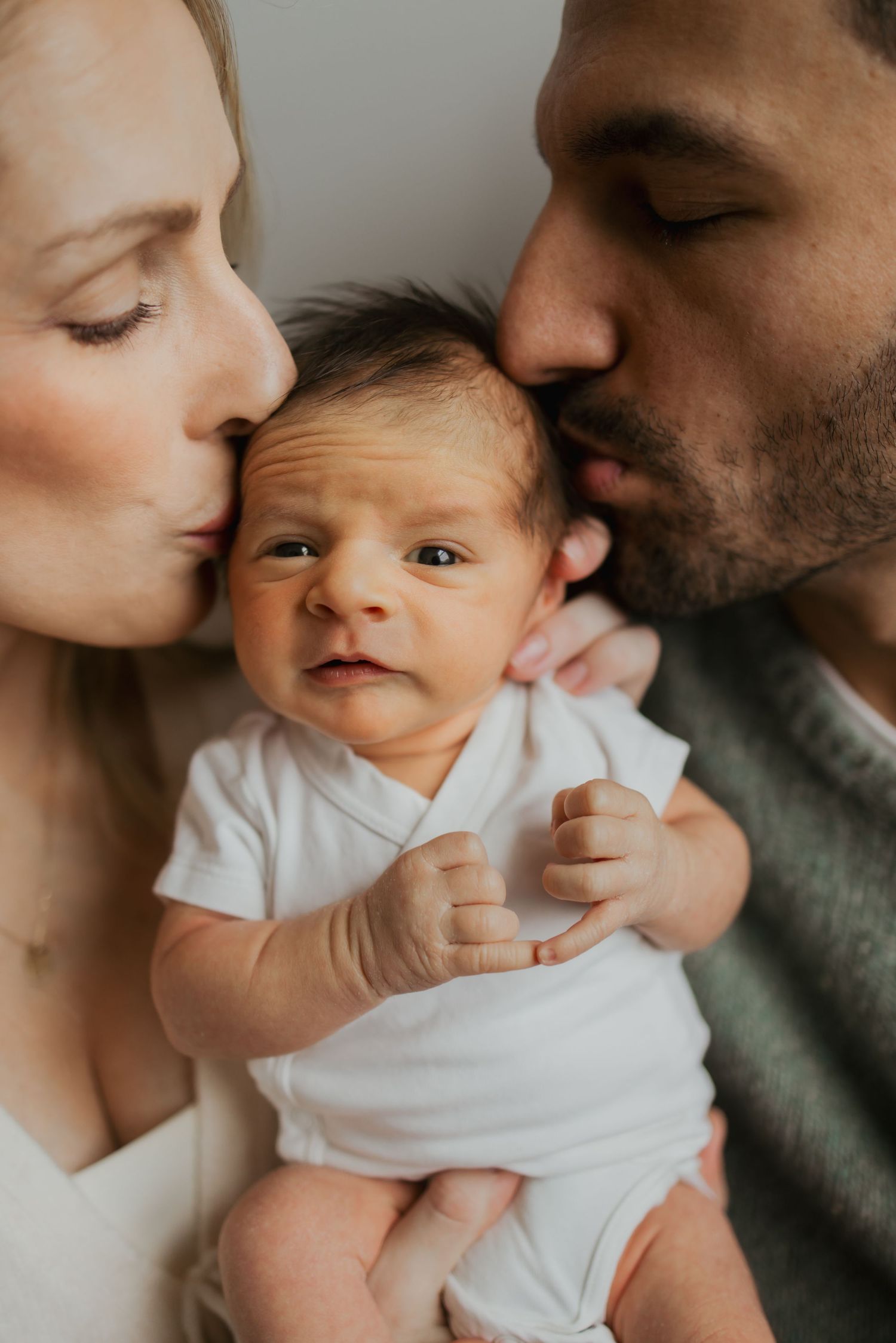 Mom and dad hold their new baby for newborn photography in Carmel Indiana