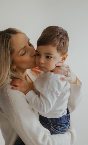 Mother, kissing her son on the cheek for family photography in Zionsville, Indiana