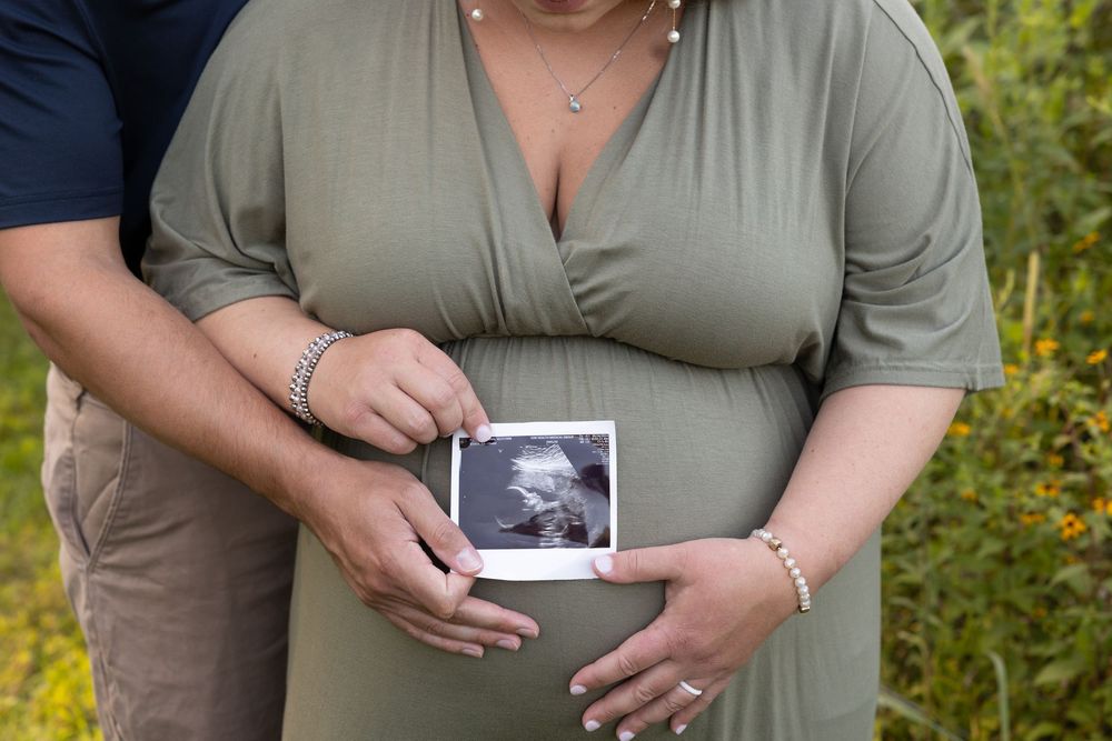 A series of cropped photos showing hands holding ultrasound images against an olive green shirt outdoors.