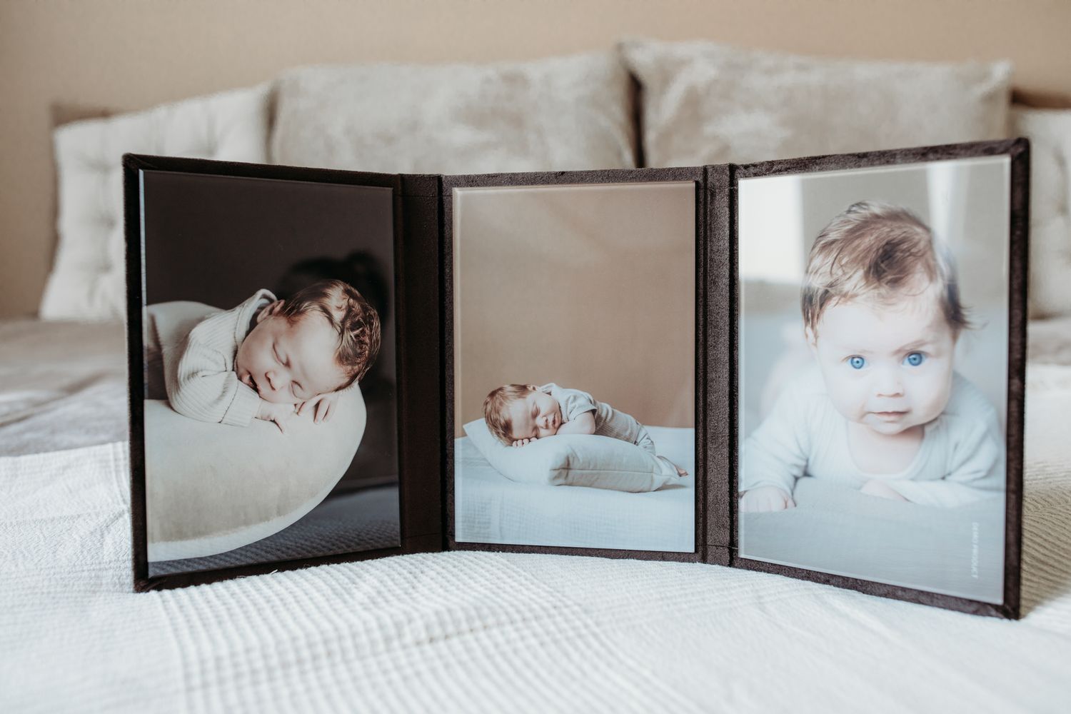 Een triplex. 3 foto's in luiken. Er zijn 3 foto's van een kleine baby te zien.