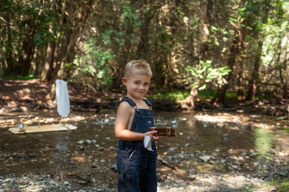 A child playing and splashing in a shallow creek on a sunny summer day.