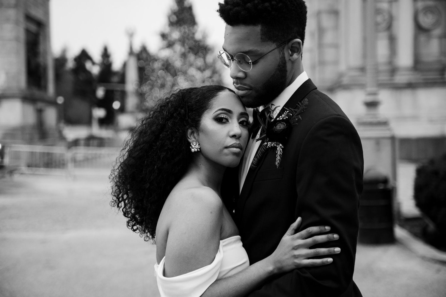 Romantic black and white portrait of newlyweds embracing outdoors.
