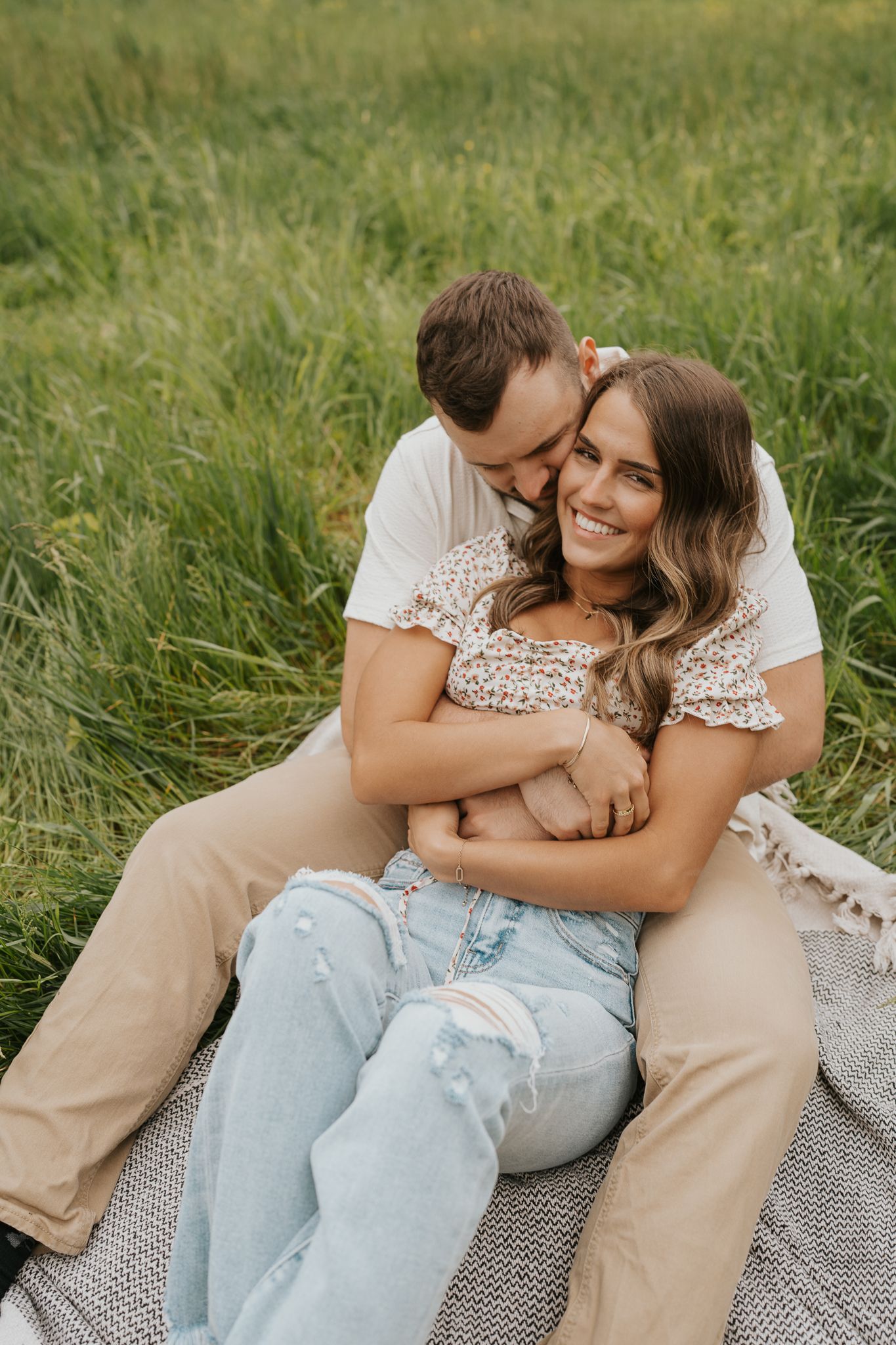 Couple cuddles together on a blanket in a wildflower meadow near Homer Michigan.